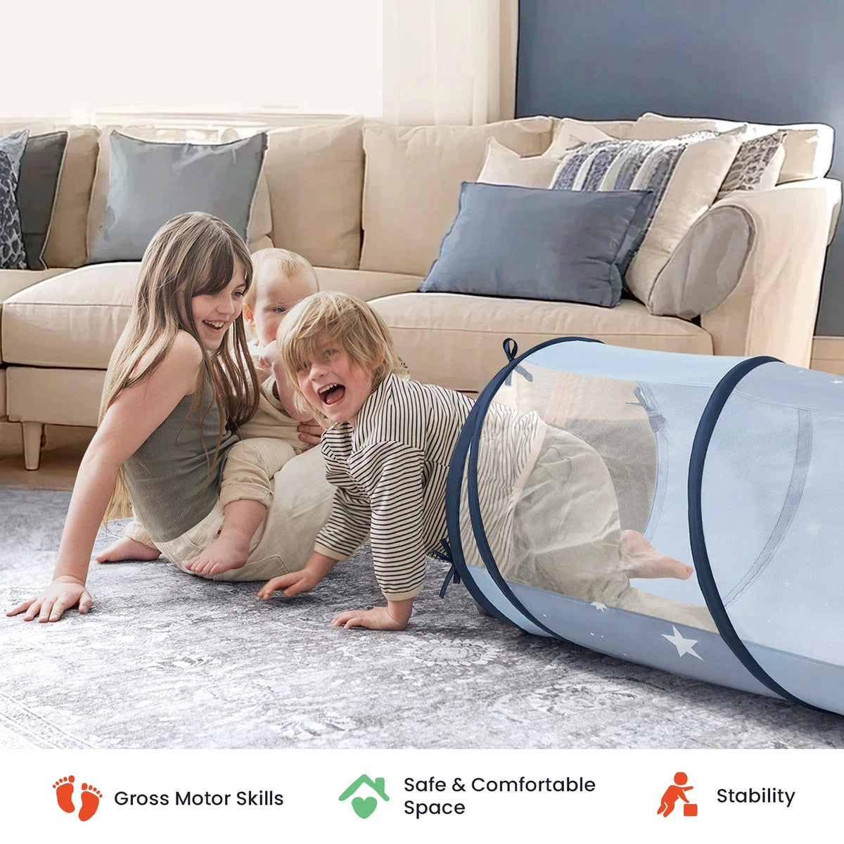 Three children laughing and playing with a blue mesh Adventure Crawl Tunnel (68″) on a living room rug.