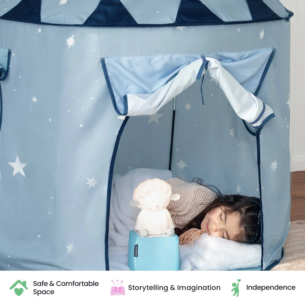 A child sleeps inside a light blue Starry Indoor Play Tent for Toddlers decorated with white stars, beside a glowing lamb-shaped nightlight.