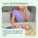 A girl sitting at a counter plays the Vocabulary Vultures Word Game by placing cards on a colorful board.