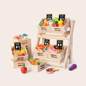 Wooden Play Food Set & Storage Rack Bundle featuring a market stand with a storage rack filled with crates of produce, meat, seafood, and baked goods, each labeled with price signs.