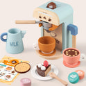 Wooden Play Coffee Maker Set featuring a toy coffee maker, milk pitcher, two cups, a slice of cake, a cookie, coffee pods, and a menu card.