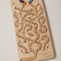 The Oort Cloud – Wooden Marble Run Puzzle featuring interlocking hexagonal tiles with carved tracks and colorful glass marbles resting at the top.
