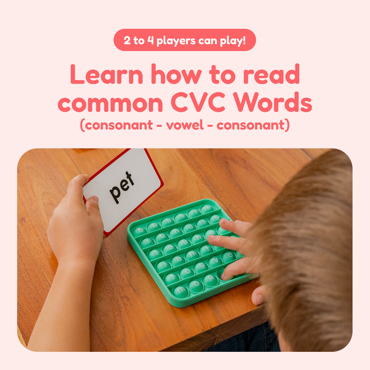 A child uses the Word Pop! + Extra CVC Mats by holding a pet card and pressing matching letters on a green, grid-like silicone sensory toy to practice blending letter sounds.