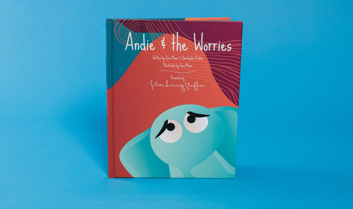 The hardcover children’s book Andie & the Worries – Picture Book features an illustrated teal elephant with large, sad eyes on a red background, a story often used for social-emotional learning.