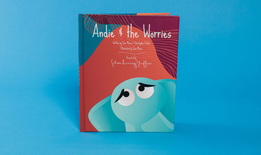 The hardcover children’s book Andie & the Worries – Picture Book features an illustrated teal elephant with large, sad eyes on a red background, a story often used for social-emotional learning.