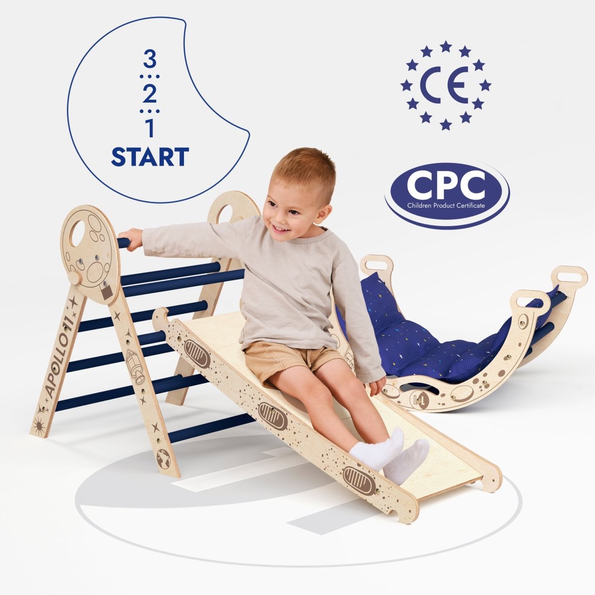 A young child sits on the wooden Apollo 4in1 Climbing Set: Pikler Triangle, Arch, Slide Board, and Cushion for Little Toddlers Astronauts (1–3 Years), featuring blue bars and a slide with playful space-themed graphics. CE and CPC certification logos are displayed in the background. This Montessori climbing set is ideal for encouraging active play with safe toddler climbing toys.