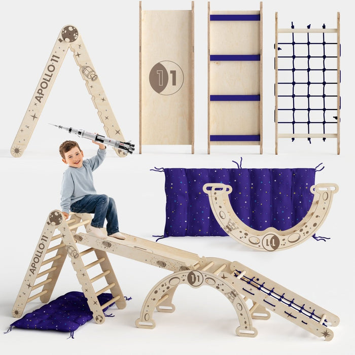 The Apollo 5-in-1 Climbing Set combines a Pikler triangle, climbing net, arch, slide, and cushion. Made of wood for indoor play, it helps sensory-motor development as kids climb and explore on soft mats below.