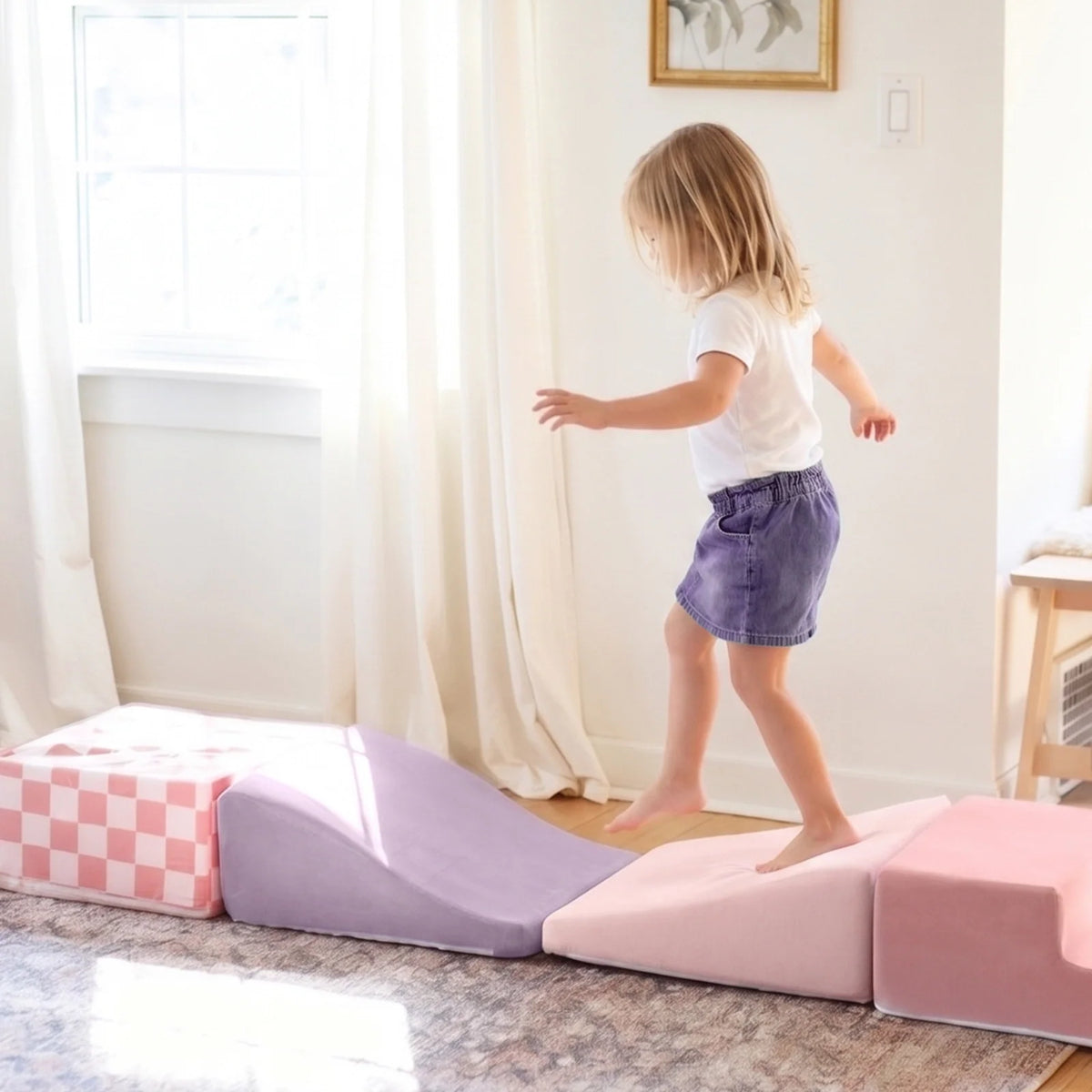 A child walks across a PlayNest Soft Foam Climbing Blocks – Violet obstacle course made of soft, foam climbing blocks in shades of pink, purple, and checkered white.