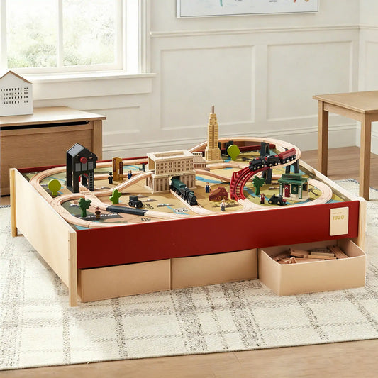 1920s Railway Wooden Train Table with Sounds featuring a built-in track, toy buildings, and train cars in a vintage city scene, with pull-out storage drawers underneath.