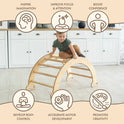 A young child climbs the Climbing Arch & Rocker Balance - Montessori Climbers for Kids 1-7 y.o. – Beige in the kitchen, with icons showing it inspires imagination, improves focus, boosts confidence, enhances control, and promotes creativity.
