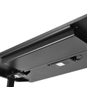 Close-up view of the underside of a black desk, showcasing a rectangular metal cable management tray, an attached control panel, and a sleek Under Desk Drawer for added under desk storage.