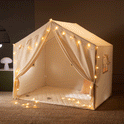 A cream-colored Large Cozy Cabin Play Tent with Star Lights framed with glowing star-shaped string lights, creating a cozy reading nook.