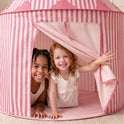 Two young children smiling inside a pink and white striped Starry Indoor Play Tent for Toddlers.