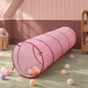 Pink and white striped Adventure Crawl Tunnel (68″) resting on a carpeted floor with several colorful plastic balls nearby.