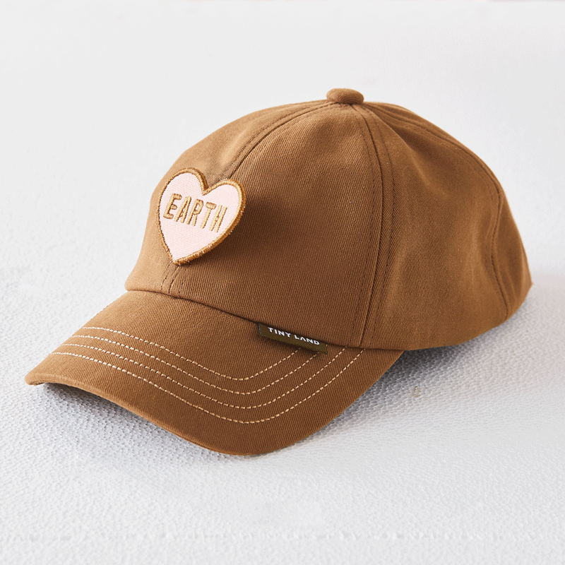 Brown baseball cap with a light pink heart patch embroidered with the word EARTH, an accessory for the BistroSwitch 2-in-1 Play Kitchen & Bistro.