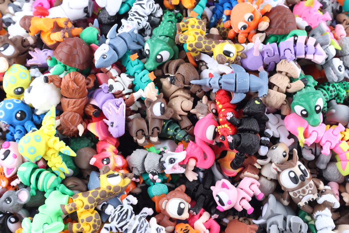 A large pile of colorful, articulated 3D-printed Mini Fidget Creatures – Surprise Pack in various animal designs.