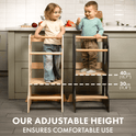 Two young children stand on separate Stable Montessori Tower: Wooden Growing Chair - Grey stools of different heights in a kitchen, demonstrating adjustable height levels at 40 cm and 30 cm. Text reads: Our Stable Montessori Tower offers comfortable, adjustable use—making it the ideal kids kitchen helper for every growing chef.