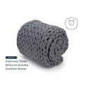 A chunky, dark gray Knit Weighted Blanket is rolled up. Text on the left reads: Improves Sleep, Reduces Anxiety, Soothes Stress. A small bear face icon is next to the blanket.