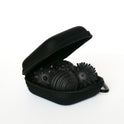 A partially open Onyx Signets case reveals three black textured massage balls with unique surface patterns, perfect for a satisfying fidgeting experience. The background is plain white.