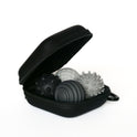 An open graphite Signets case displays three textured massage balls, each with unique patterns and raised bumps designed to enhance focus and offer a soothing fidgeting experience.