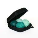 The Signets set features three uniquely textured turquoise massage balls in a compact black zippered case, offering satisfying fidgeting and improved focus throughout your day.