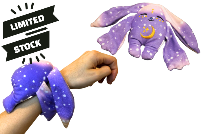 A purple, star-patterned Polli Mini Wrist Hugger – Magnetic Sensory Plush wrapped around a person’s wrist, with a matching plush rabbit floating above next to a Limited Stock banner.