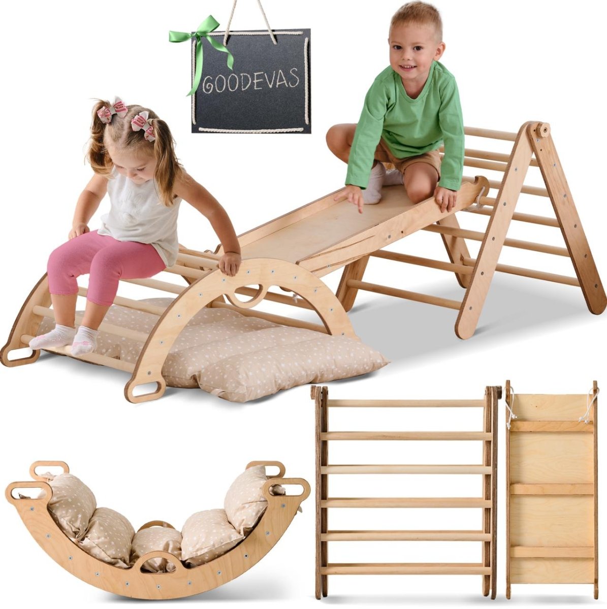 Two young children play on a beige Pikler Triangle Set for Toddlers, which includes a triangle ladder, climbing arch, slide board, and cushion. The pieces are arranged creatively with a Goodevas chalkboard sign visible.