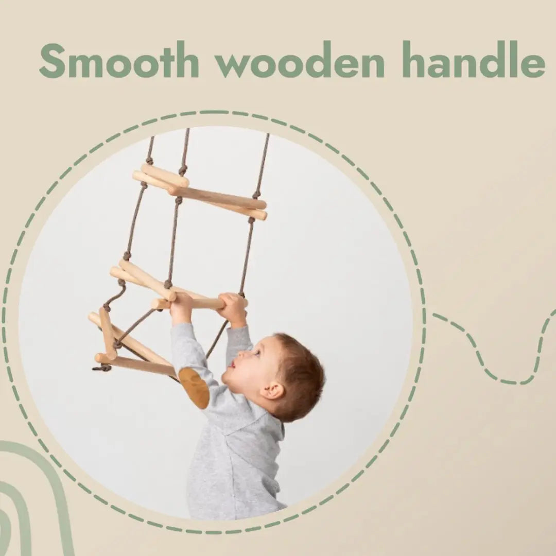 A young child in a gray shirt is holding onto the Triangle rope ladder for kids, gripping the smooth wooden handle of this developmental climbing toy while looking up at the rungs. The text above reads, Smooth wooden handle.
